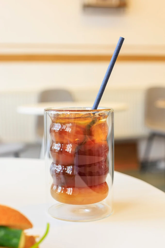 A glass of Vietnamese drip coffee being prepared with a traditional phin filter on top.